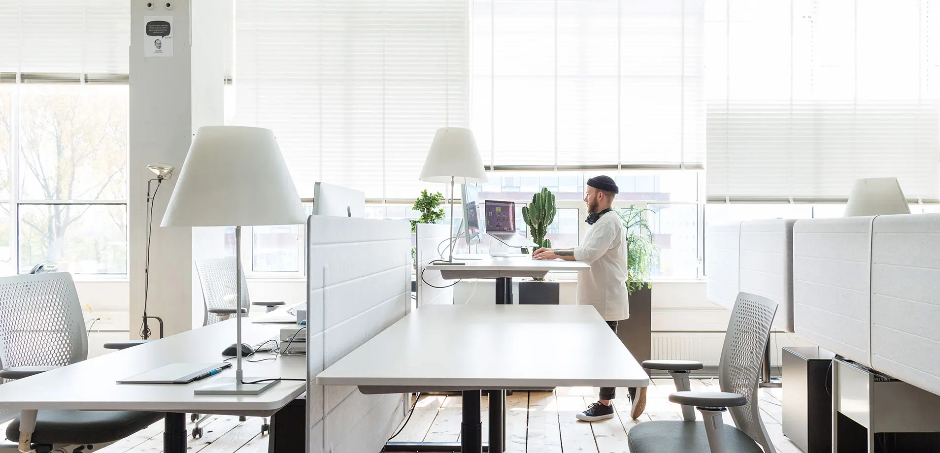 main project image of a man standing infront of a desk, looking at a screen